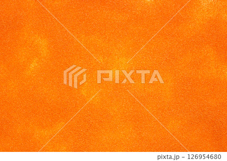 Here is a detailed close up image featuring a piece of bright orange glitter Here is a detailed close up image featuring a piece of bright orange glitter 126954680