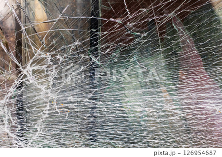 This is a close up view featuring a broken glass window 126954687