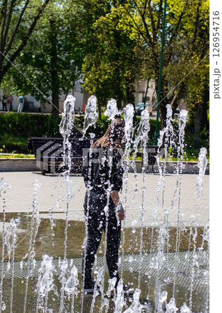 A woman stands in a beautiful fountain with mesmerizing water flow 126954716
