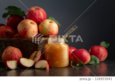 Apple jam and fresh apples on a black stone table. Apple jam and fresh apples on a black stone table. 126955041