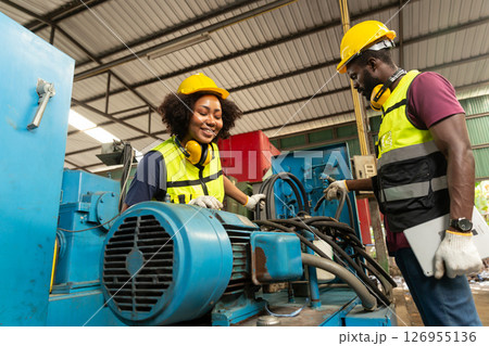 professional engineer worker male help assisting young women worker to check service old machine in heavy industry plant professional engineer worker male help assisting young women worker to check service old machine in heavy industry plant 126955136