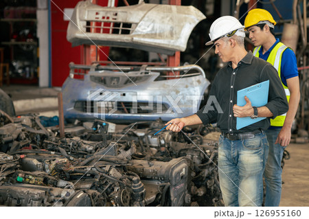 used car part business owner working check stock order with young technician man in second hand vehicle spare part center warehouse 126955160