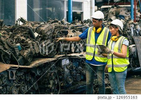 used car part business worker checking second hand car engine block, vehicle spare part center warehouse fore sale in scrapyard used car part business worker checking second hand car engine block, vehicle spare part center warehouse fore sale in scrapyard 126955163