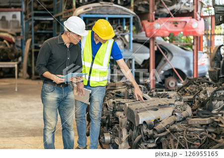 used car part business owner working check stock order with young technician man in second hand vehicle spare part center warehouse used car part business owner working check stock order with young technician man in second hand vehicle spare part center warehouse 126955165