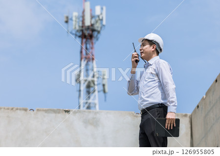 Construction project engineer in action asian builder at telecommunications site urban environment professional viewpoint 126955805