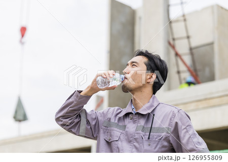 Asian worker male thirsty drinking water in hot summer weather working outdoor at construction site 126955809