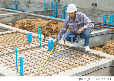 Asian construction engineer, Japanese builder worker male working inspecting footing house building. 126955814