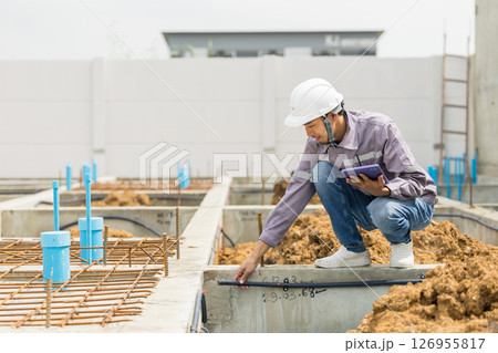 Asian construction engineer, Japanese builder worker male working inspecting footing house building. 126955817