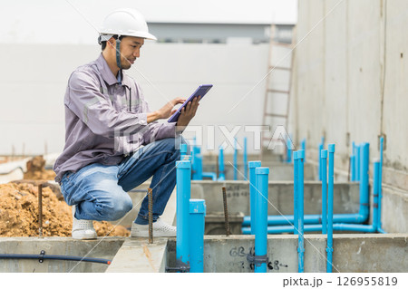 Asian construction engineer, Japanese builder worker male working inspecting footing house building. 126955819