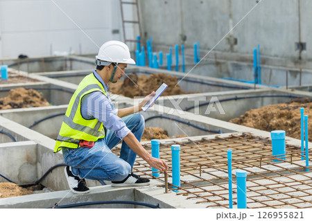 Asian construction engineer, Japanese builder worker male working inspecting footing house building. 126955821