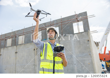 Professional construction engineer builder using UAV Drone to help assist construction site inspect 126955824