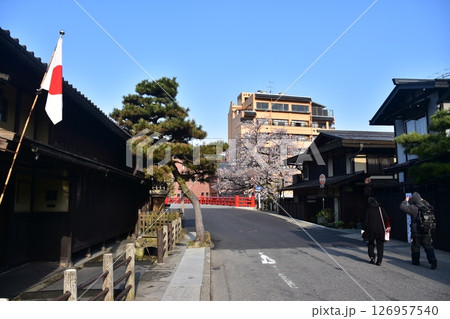 日本の岐阜県　春の高山市　満開の桜と観光名所の中橋　日本国旗を掲げる古民家と散歩を楽しむ観光客 126957540