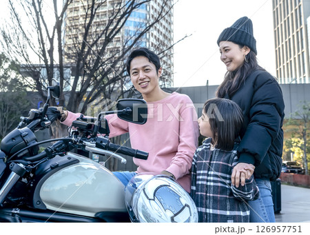 念願の大型バイクを手に入れた男性と寄り添う妻と子供 126957751