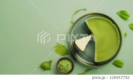 Matcha cheesecake and flour topping on plate copy space on green background 126957782
