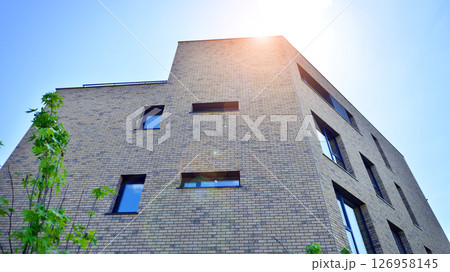 Eco architecture. Green tree and new residential building. Harmony of nature and modernity. Modern apartment building with new apartments in a green residential area. Eco architecture. Green tree and new residential building. Harmony of nature and modernity. Modern apartment building with new apartments in a green residential area. 126958145