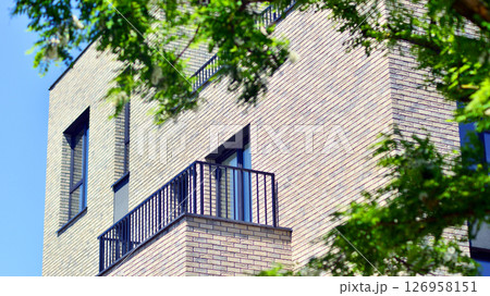 Eco architecture. Green tree and new residential building. Harmony of nature and modernity. Modern apartment building with new apartments in a green residential area. 126958151