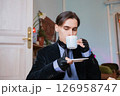 young elegant rich heir man drinking morning coffee in a sophisticated room decorated with vintage elements in his mansion 126958747