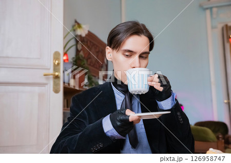 young elegant rich heir man drinking morning coffee in a sophisticated room decorated with vintage elements in his mansion young elegant rich heir man drinking morning coffee in a sophisticated room decorated with vintage elements in his mansion 126958747