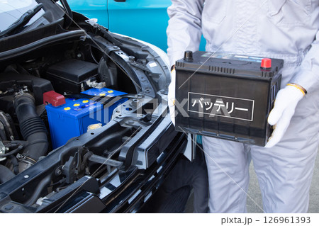 車のバッテリーを持つ整備士 126961393