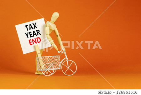 Tax year end symbol. Concept words Tax year end on beautiful white card. Beautiful orange background. Businessman model. Business tax year end concept. Copy space. Tax year end symbol. Concept words Tax year end on beautiful white card. Beautiful orange background. Businessman model. Business tax year end concept. Copy space. 126961616