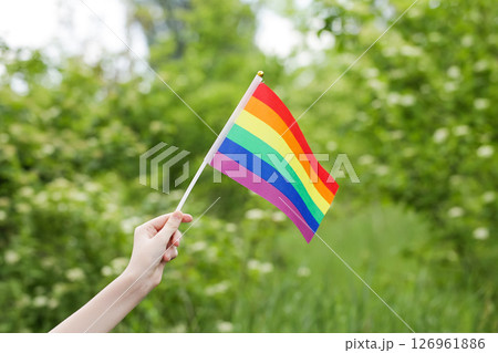 Teenager Holds Rainbow Flag LGBT in his Hands. Pride Month. Lesbian Gay Bisexual Transgender. Love, human rights, tolerance Teenager Holds Rainbow Flag LGBT in his Hands. Pride Month. Lesbian Gay Bisexual Transgender. Love, human rights, tolerance 126961886