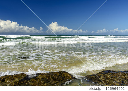 Small waves on a deserted and rocky beach Small waves on a deserted and rocky beach 126964402