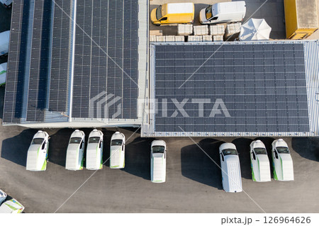 Delivery vans and trucks hub with solar panels on a roof. Fleet of vehicles Delivery vans and trucks hub with solar panels on a roof. Fleet of vehicles 126964626