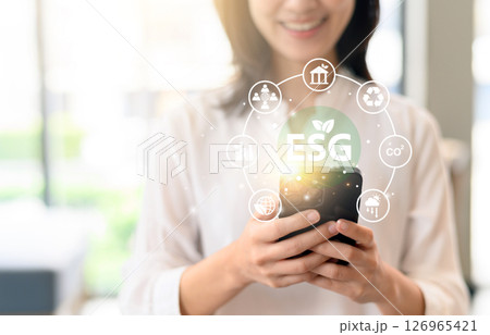 Women analyze ESG icons smartphone for sustainable corporate business investment strategy. Organization focus environment social governance development goals path to achieve positive business change Women analyze ESG icons smartphone for sustainable corporate business investment strategy. Organization focus environment social governance development goals path to achieve positive business change 126965421