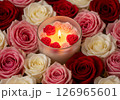 candle featuring floating miniature rose petals, surrounded by vibrant pink and red roses, creating a romantic and luxurious ambiance perfect for relaxation 126965601