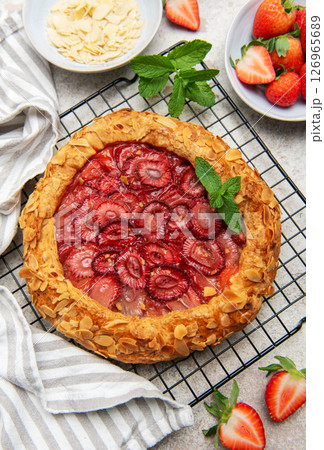 Delicious homemade strawberry galette decorated with almond petals and fresh mint 126965689