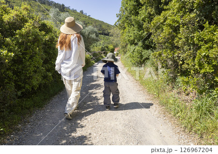 Mother and son walking on country road enjoying sunny day Mother and son walking on country road enjoying sunny day 126967204