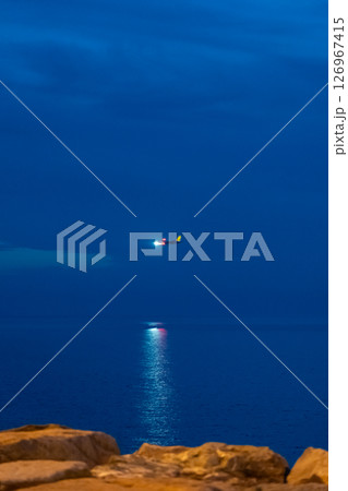 A plane landing over the sea at night. reflection in the water 126967415