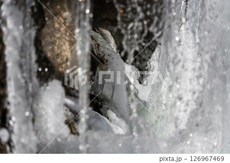 Water jets of a waterfall nearby. Waterfall in winter 126967469