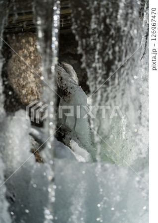Water jets of a waterfall nearby. Waterfall in winter 126967470