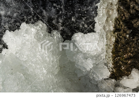 Water jets of a waterfall nearby. Waterfall in winter 126967473