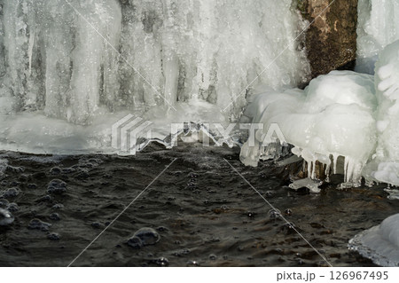 Frozen waterfall. Huge chunks of ice. Blocks of ice in the waterfall Frozen waterfall. Huge chunks of ice. Blocks of ice in the waterfall 126967495