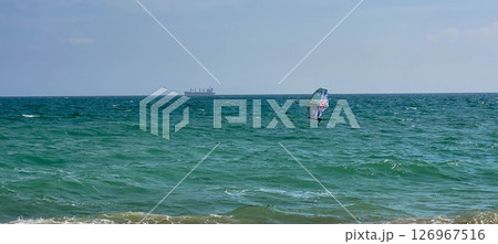 Sea sports Windsurfing. Surfer, surfing on the water in the sea on a sunny day 126967516