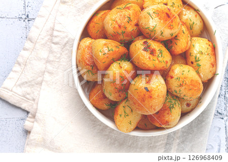 Baked new potatoes, with butter and dill, on a white plate, at home, no people, Baked new potatoes, with butter and dill, on a white plate, at home, no people, 126968409