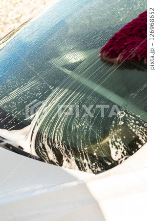 Efficiently cleaning an electric car in the comfort of a suburban driveway, combining eco-consciousness with practicality. Efficiently cleaning an electric car in the comfort of a suburban driveway, combining eco-consciousness with practicality. 126968652