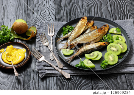 Hot smoked Baltic herrings with kiwi fruit slices Hot smoked Baltic herrings with kiwi fruit slices 126969284
