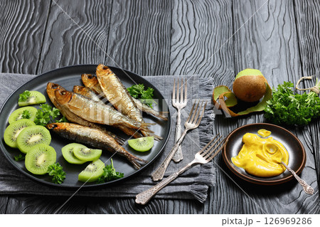 Hot smoked Baltic herrings with kiwi fruit slices 126969286