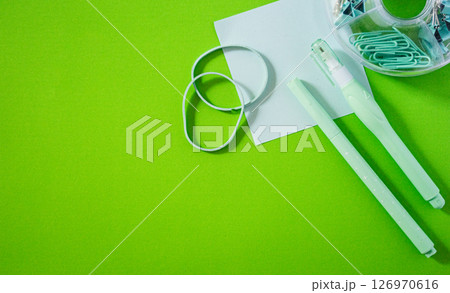 Top view of office supplies items arranged on a smooth, glossy background. 126970616