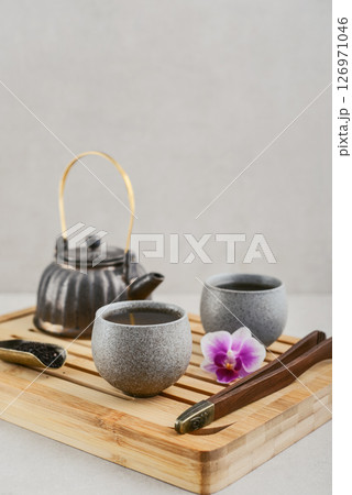Traditional asian tea ceremony arrangement: ceramic teapot, cups and bamboo chaban Traditional asian tea ceremony arrangement: ceramic teapot, cups and bamboo chaban 126971046