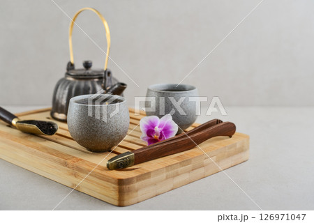 Traditional asian tea ceremony arrangement: ceramic teapot, cups and bamboo chaban Traditional asian tea ceremony arrangement: ceramic teapot, cups and bamboo chaban 126971047