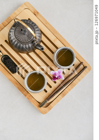 Traditional asian tea ceremony arrangement: ceramic teapot, cups and bamboo chaban Traditional asian tea ceremony arrangement: ceramic teapot, cups and bamboo chaban 126971049