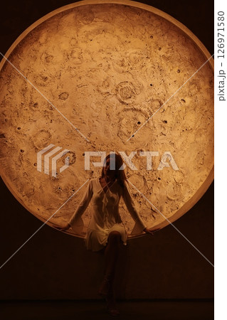 Experience an incredibly captivating view of a stunning celestial body with a figure above it Experience an incredibly captivating view of a stunning celestial body with a figure above it 126971580