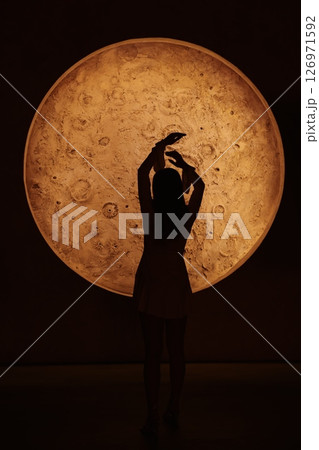 The Silhouette of Hands is posed against a Glowing Orb, enhancing atmosphere and appeal The Silhouette of Hands is posed against a Glowing Orb, enhancing atmosphere and appeal 126971592