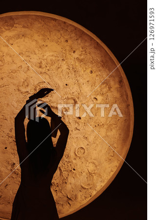 A Beautiful Silhouette of a Dancer Set Against a Captivating Moonlit Background Scene 126971593