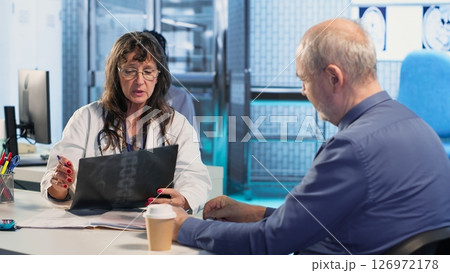 Medic gives a bad concerning diagnosis to elderly patient at checkup, offering support and advice to try a recovery plan. Dangerous health problems for a senior man. Camera B. 126972178