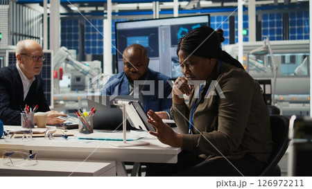 Photovoltaics plant researchers work on breakthroughs in durability and performance in office. Factory experts testing materials for next generation solar panels, doing research and development 126972211